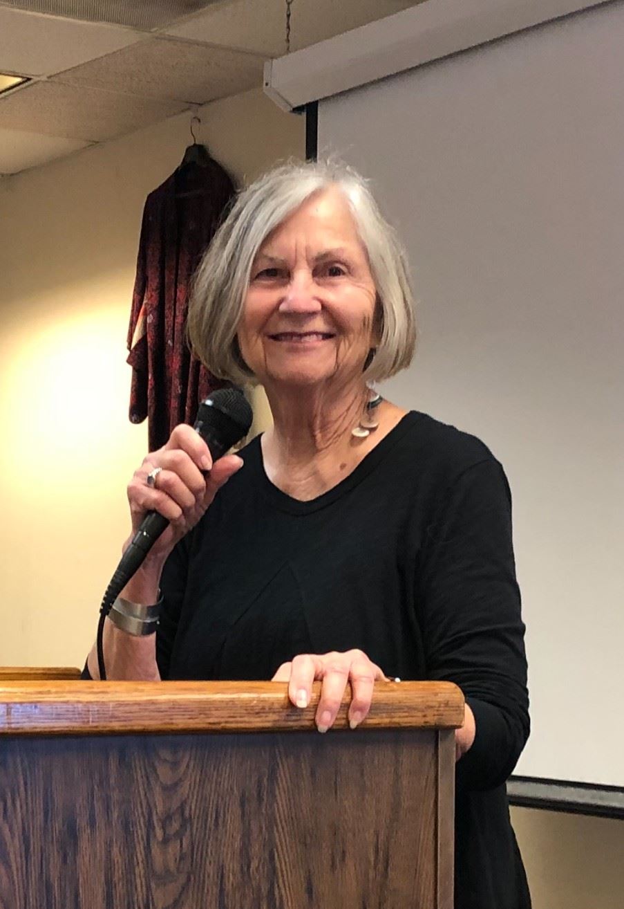 Alex Stillman at dais with microphone